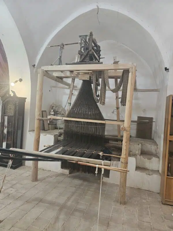 Lomyna Brand Story 1 An antique hand-loom used for weaving traditional fabrics and towels, showcasing intricate mechanisms