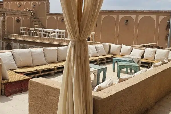 Traditional desert home interior with hand-woven textile curtain, wooden pallet seating, and natural cotton cushions