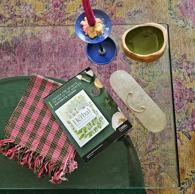 Folded Lomyna LOSA towel placed on a living room table next to magazines, with a rug visible under the table.