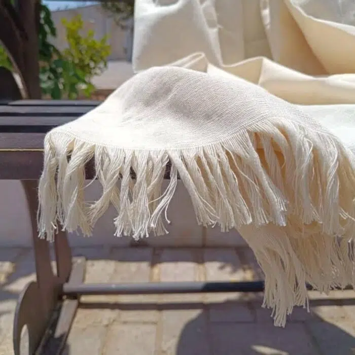 LOCO Hand-Woven Hammam Towel in its natural, unbleached cotton color, displayed in sunlight, showcasing Natural Purity, Ultra weave, and the positive energy of Timeless Luxury for spa/travel use.