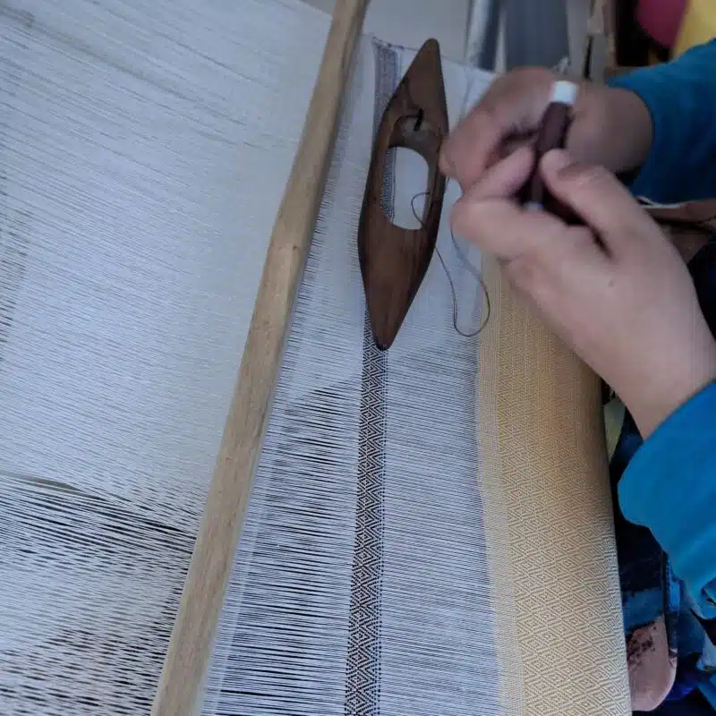 Lomyna Brand Story 1 Artisan weaving textiles on a traditional wooden loom for the Lomyna Brand Story